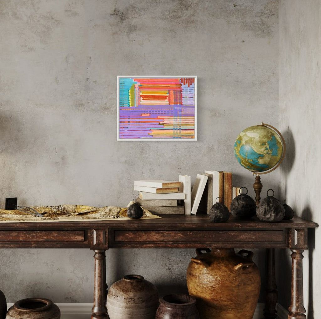 The artwork 'It's Layered (Bingin)' by Taylor Binda features geometric abstract composition with vibrant horizontal and vertical stripes in pastel purple, coral orange, and turquoise blue. The acrylic painting on canvas showcases a layered architectural-style design with clean lines and modern color blocking, framed in white and measuring 16x20 inches by Taylor Binda.