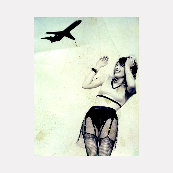 The artwork 'Cherry with Plane on the Roof' depicts a silhouetted airplane against a pale mint-green sky. The composition features a vintage-style artistic photograph with a dreamy, nostalgic quality. The image showcases contrasting elements in black and light tones, creating a dynamic visual tension. Editioned signed photo by Dirk Westphal.