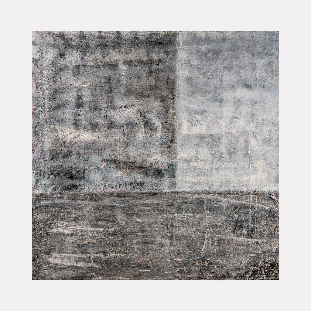 The artwork 'Gray Matter' by Jordan Barker features a minimalist abstract composition divided into contrasting sections of deep and light gray tones. The textured surface suggests weathered concrete, with scratched markings and varied brush strokes creating depth and dimension across the 48-inch square canvas. Mixed media elements add industrial, raw character to the monochromatic palette.