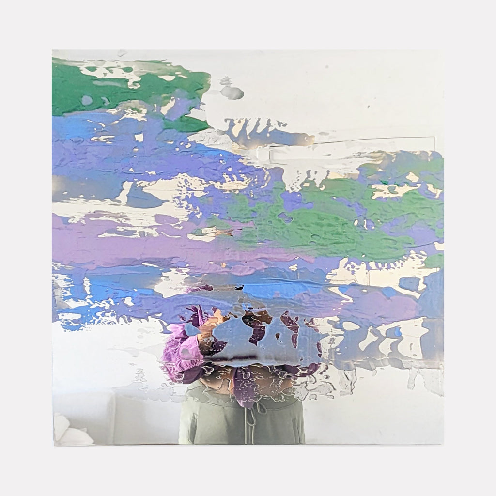 The artwork 'Remnants' by Sofia Echa features abstract layers of pastel colors on stainless steel. Horizontal brushstrokes create a dreamy landscape effect with soft blues, lavenders, and sage greens. The acrylic paint creates textural elements with areas of opacity and transparency, while the metallic surface adds reflective depth and luminosity to the 24x24 inch composition.