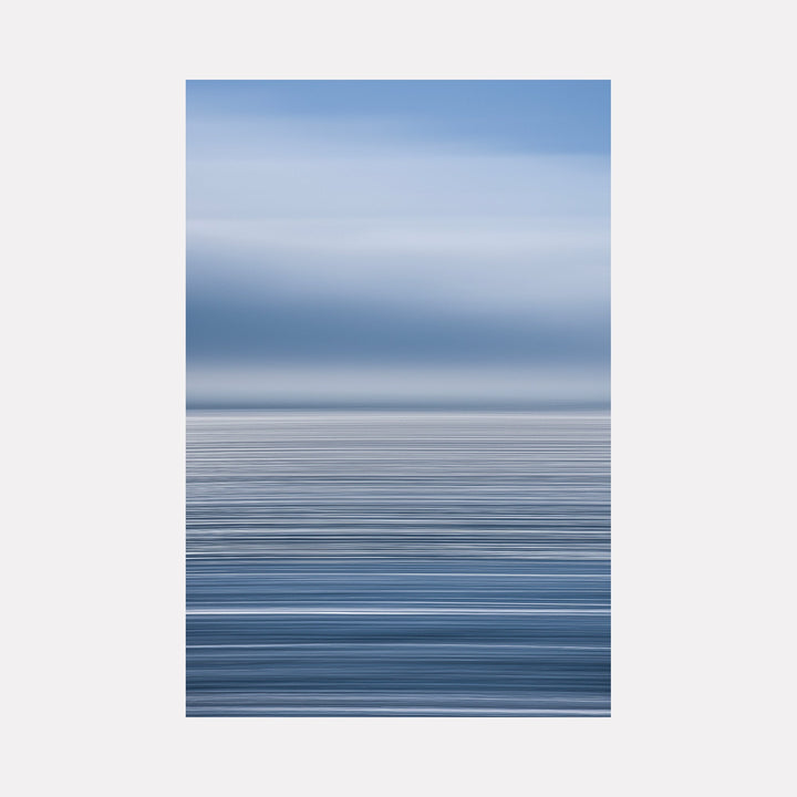 The artwork 'Sun Streaks on Pacific' by Neil Shapiro features a minimalist seascape composition with horizontal bands of graduated blue tones. The image captures a serene ocean surface with subtle streaks of light, transitioning from deep navy at the bottom to soft powder blue at the horizon, printed on textured Hahnemuhle paper.