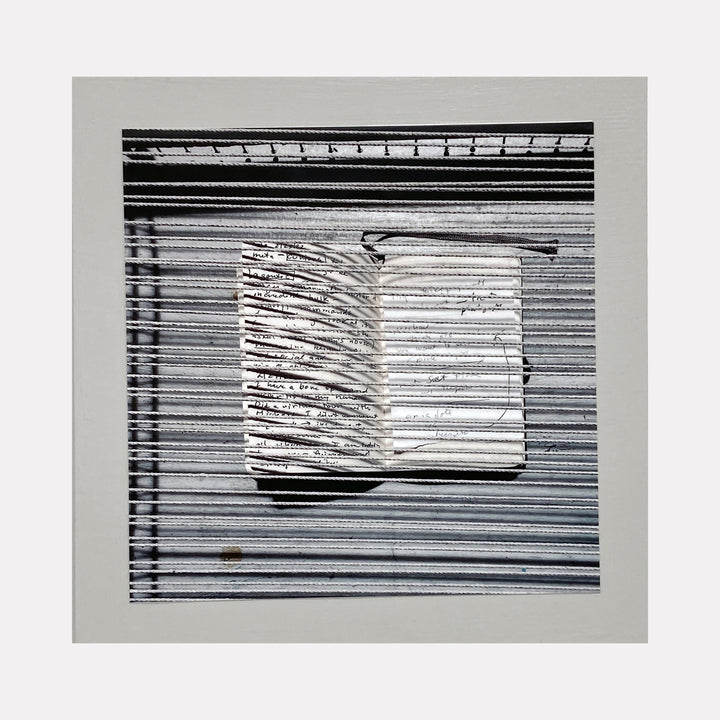 The artwork 'Sentence Structure String 1' by Anne Sherwood Pundyk features a monochromatic composition with parallel horizontal lines creating a textured background. A central white rectangular form emerges, marked with abstract linear notations resembling text or musical notation. The piece combines stark black and white contrast in an archival inkjet print mounted on wood panel.