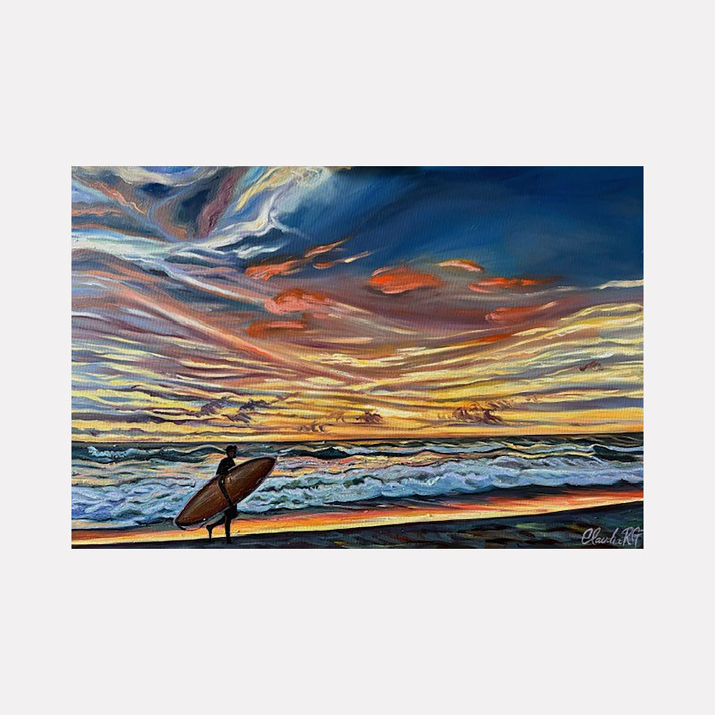 The artwork 'Towards Heaven's Gates' by Claudia Robles-Gil captures a silhouetted surfer on a beach at sunset, against dramatic swirling clouds in vibrant oranges, yellows, and deep blues. Rolling ocean waves crash along the shoreline, while the sky showcases masterful oil and acrylic brushwork creating dynamic, flowing patterns of light and color. 24x36 inches canvas painting by Claudia Robles-Gil.