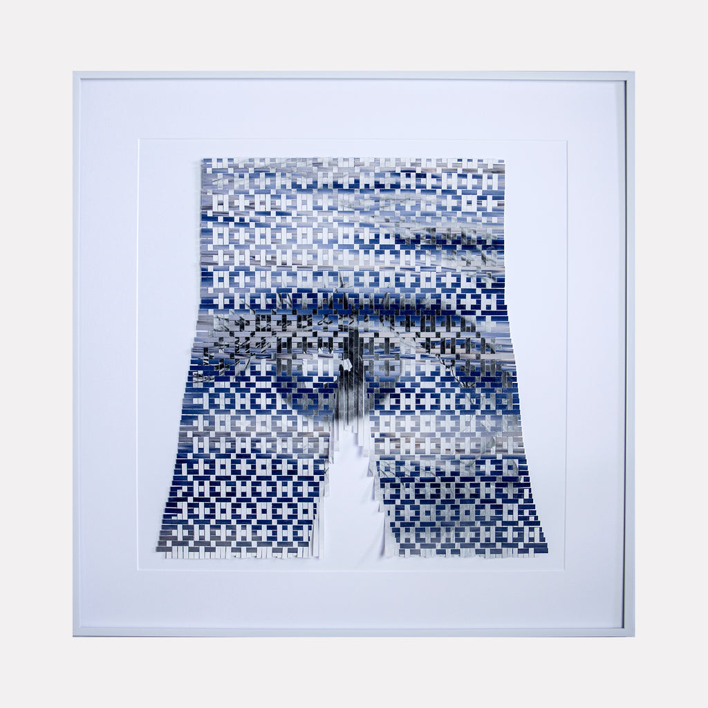 The artwork 'Twilight Reflection' by Kiana Honarmand features a pixelated pattern in shades of blue, white, and gray arranged in a trouser-like shape. The geometric design creates a mosaic effect with small squares forming horizontal bands across the piece. The composition displays a digital glitch aesthetic, with a central vertical split creating a mirror-like reflection. Mounted in a clean white frame, this 28x28 inch contemporary artwork combi