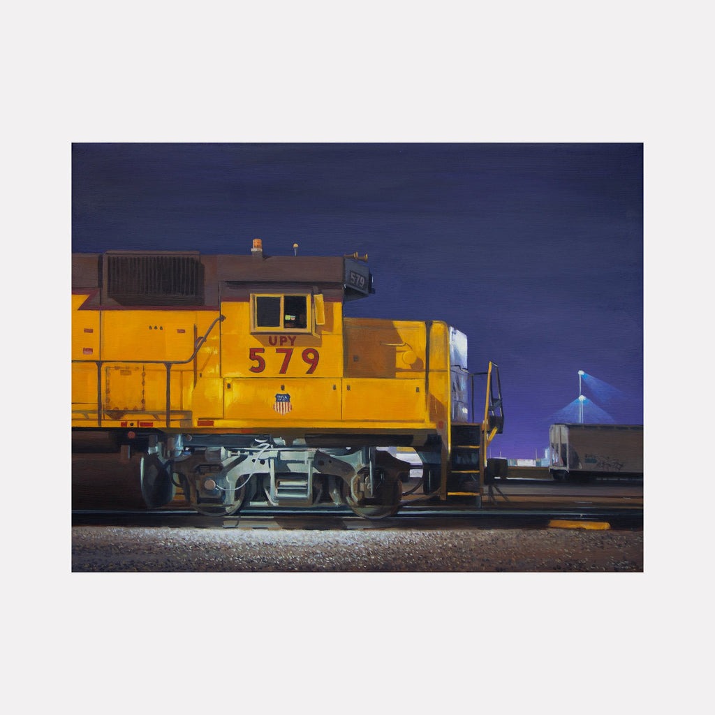The artwork 'UNION-579' by Alex Devereux captures a striking yellow Union Pacific locomotive against a deep blue night sky. The train's number 579 is prominently displayed on its side, with industrial details and mechanical components visible beneath. The dramatic nighttime lighting creates strong contrasts, highlighting the train's vibrant color and metallic textures in this 12x16 inch acrylic painting on canvas.