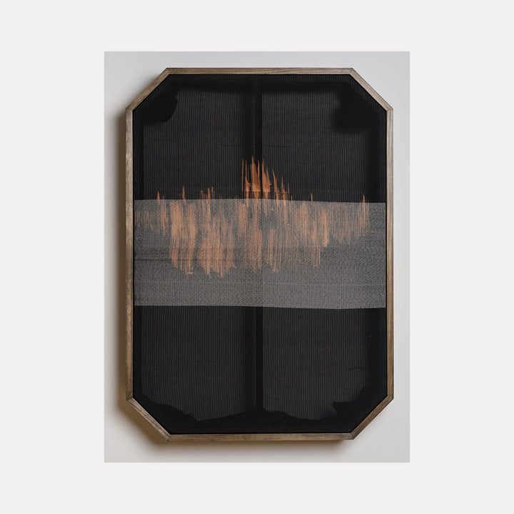 The artwork 'Untitled 104' by Victoria Manganiello features a minimalist fiber composition with a horizontal band of copper-toned weaving across charcoal black background. The textural piece, framed in a geometric wooden border, showcases natural and synthetic fibers creating an abstract horizon-like effect, with subtle variations in weave density.