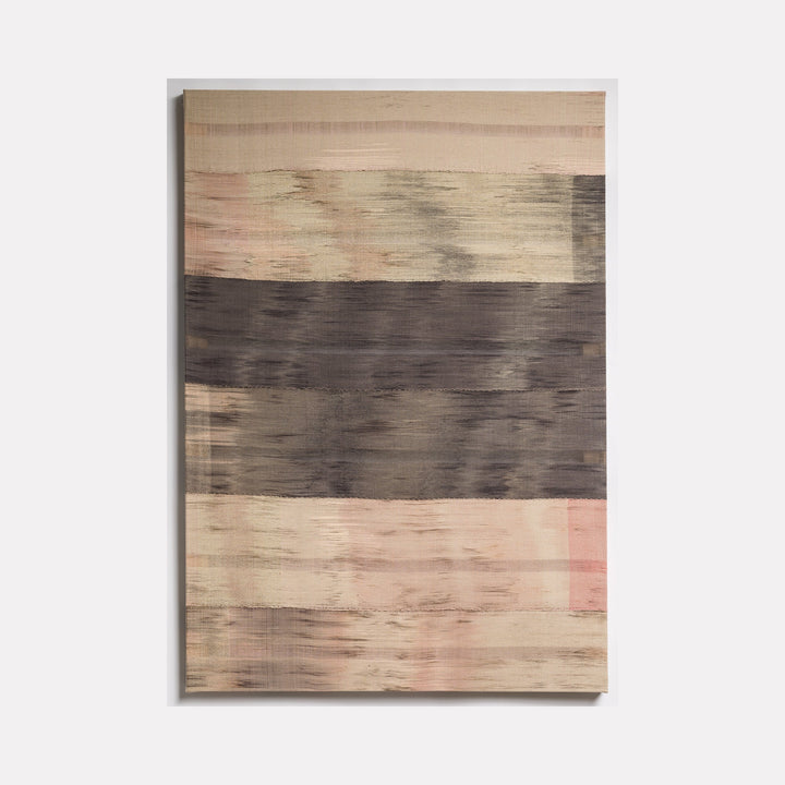 The artwork 'Untitled 69' by Victoria Manganiello features horizontal bands of contrasting colors, with soft beige and blush tones separated by a bold charcoal stripe across the center. The textile piece showcases a weathered, brushstroke-like texture created through natural and synthetic fibers, measuring 54 by 38 inches.
