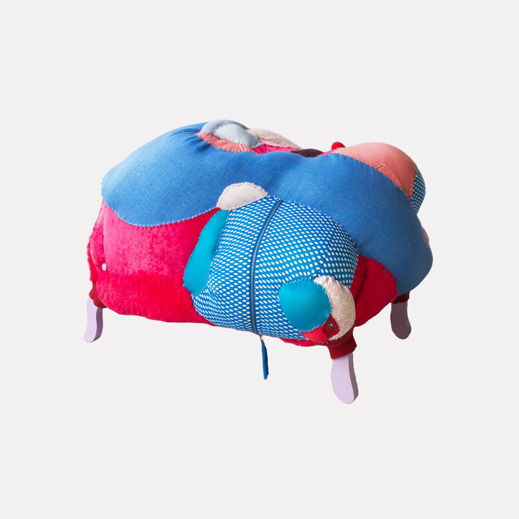 Re-recovered by Hanna Washburn is a vibrant textile sculpture combining plush, rounded forms in contrasting fabrics including bright pinks, blues, and patterned texures. The piece features layered stitching and soft tubing elements arranged in an abstract, playful composition that evokes warmth and tactile curiosity.