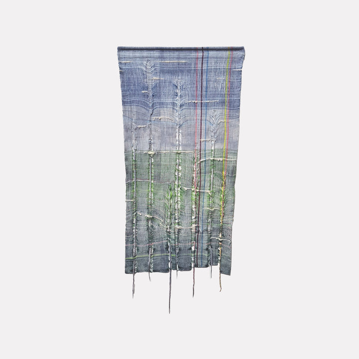 The artwork "Cattail Apparitions" by Johanna Ryan features a woven tapestry with hand dyed yarn and raw wool, depicting abstract cattail shapes in textured layers of blue, green, and subtle earth tones with vertical lines and fringe details. The piece measures 48.5 inches high by 22.75 inches wide.