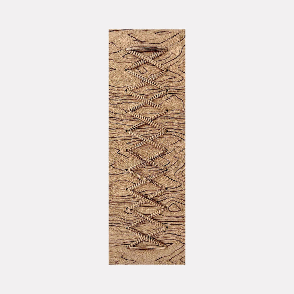 The artwork "Cross Stitch" by Quynn Douglas Dale features a rectangular wooden panel with natural grain patterns in warm brown tones. The piece showcases an intricate geometric crisscross design carved into the surface, evoking minimalist and abstract styles similar to the precision and texture found in works by Agnes Martin. The tactile quality emphasizes craftsmanship and organic materiality.
