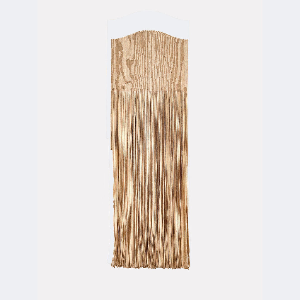 The artwork "Paunch" by Quynn Douglas Dale features a vertical wooden panel with natural grain patterns in light brown tones. The top section is smoothly curved, while the lower portion extends into long, thin fringes that create texture and movement. The piece echoes minimalist and organic styles reminiscent of Eva Hesse's tactile sculptures.