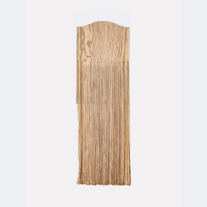 The artwork "Paunch" by Quynn Douglas Dale features a vertical wooden panel with natural grain patterns in light brown tones. The top section is smoothly curved, while the lower portion extends into long, thin fringes that create texture and movement. The piece echoes minimalist and organic styles reminiscent of Eva Hesse's tactile sculptures.