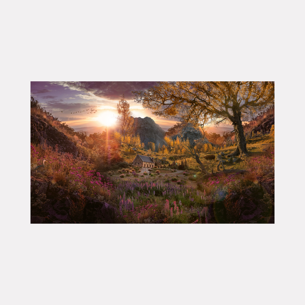 Sunset Valley by Nash Bellows depicts a glowing countryside scene at dusk, where golden light bathes rolling hills and a quaint stone cottage surrounded by vibrant wildflowers. Towering trees with autumn foliage frame the view, while distant mountains stand beneath a dramatic sky filled with soft clouds and flying birds, evoking peaceful warmth and natural beauty.
