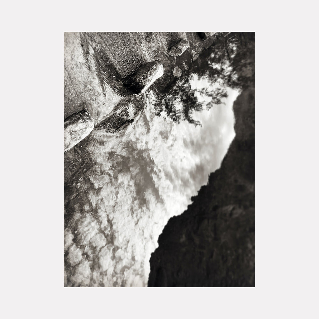 The artwork Sabino Creek WPA Bridge #1 by Ann Tracy features an abstract, textured landscape in monochrome tones, blending rough stone forms with dynamic, cloud-like patterns. The composition evokes the atmospheric depth found in works by Ansel Adams and the surreal textures reminiscent of Georgia O'Keeffe’s natural abstractions.