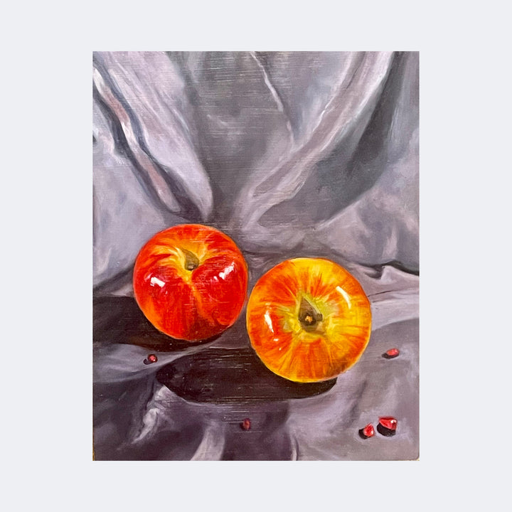 The artwork "Fruit and Seeds III" by Regina Miele features two vibrant red and orange apples set against a textured, draped gray fabric background. The realistic style, with detailed reflections and subtle shadows, evokes a classic still life reminiscent of works by artists like Caravaggio and Giorgio Morandi, emphasizing natural forms and rich color contrasts.