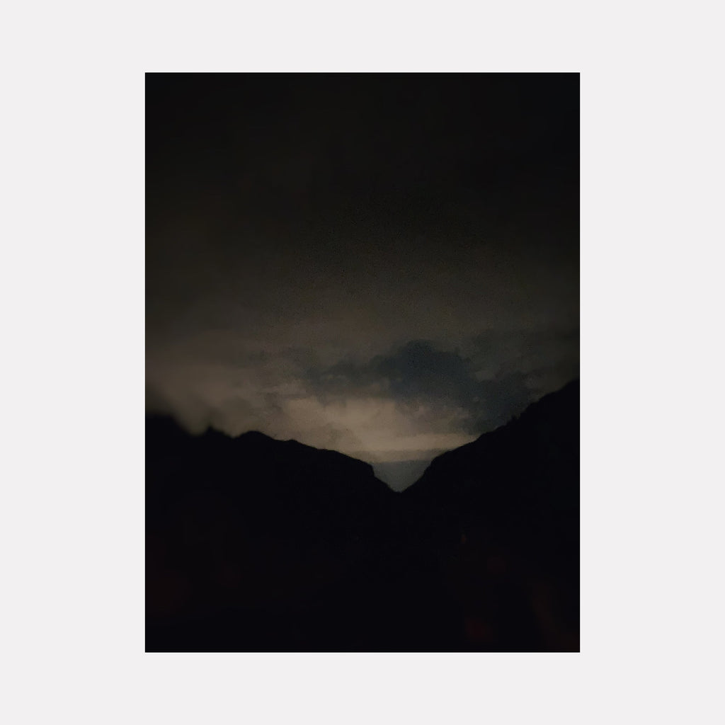 The artwork "Sabino Canyon Dusk" by Ann Tracy features a dark, moody landscape with silhouetted mountain shapes against a dimly lit sky. The subtle gradation of deep blues and greys evokes the quiet twilight atmosphere reminiscent of the tonal softness found in works by James McNeill Whistler and the minimalist approach of Mark Rothko, emphasizing mood over detail.