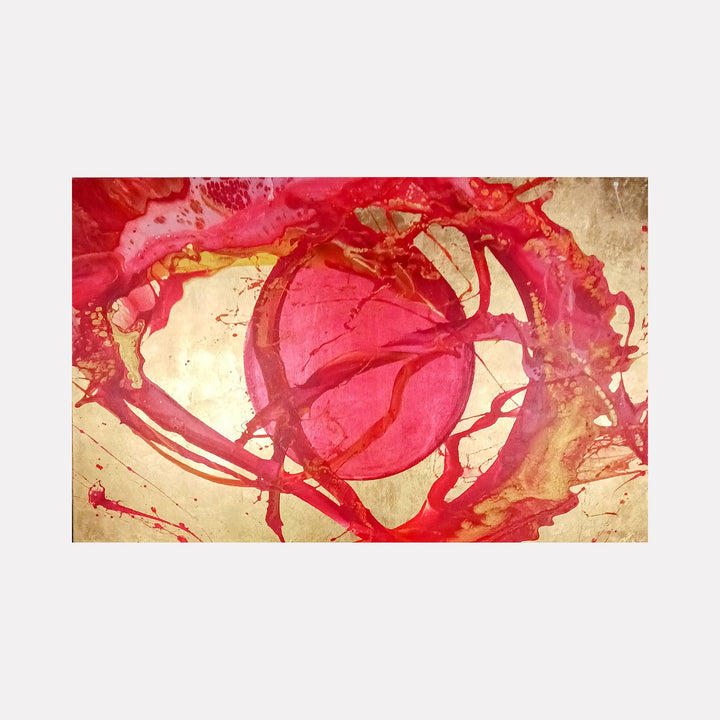 The artwork 'Ablaze' by Nicholas Franklin features dynamic swirls of vibrant red and pink acrylic paint against a warm golden background. The abstract composition shows fluid, energetic brushstrokes creating circular movements, with paint splatters and organic forms suggesting intense motion and heat. The contrast between the fiery reds and metallic gold base creates a striking visual impact.