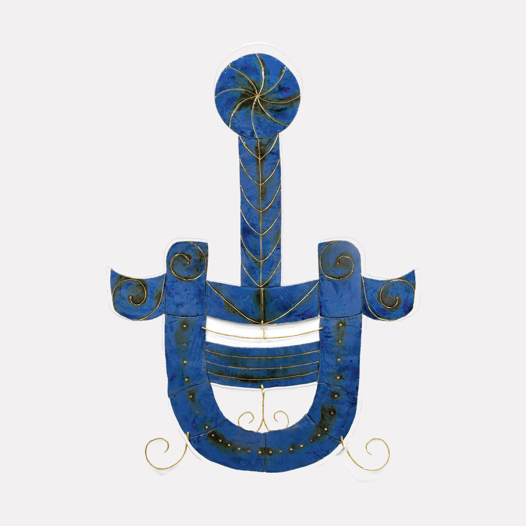 The artwork BLT by Adina Andrus features an abstract design with deep blue curved and linear shapes accented by gold wire details. The composition evokes a sense of balance and fluidity reminiscent of Joan Miró’s surreal abstract forms and the textured depth found in Paul Klee’s works. The piece blends modernist sculpture with playful organic patterns.