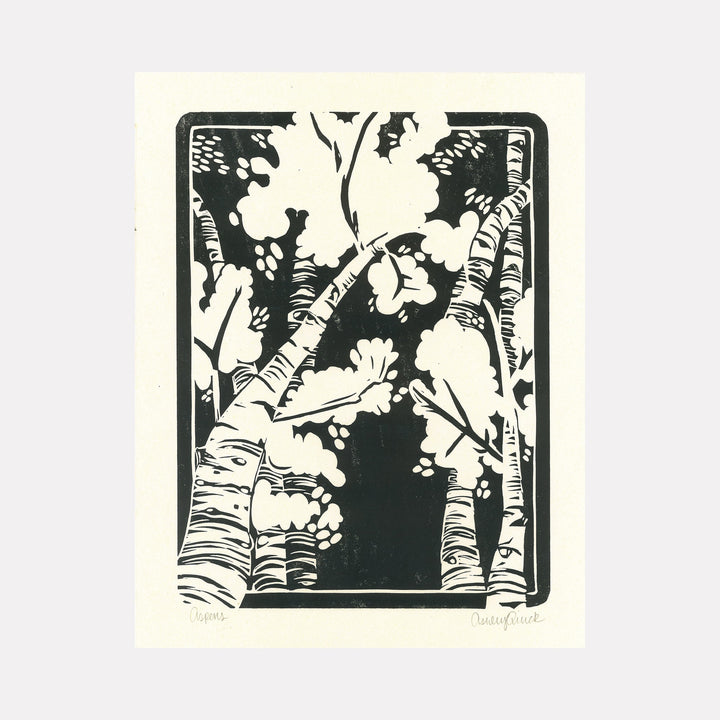 The artwork "Aspens" features stylized black and white birch trees with textured bark and abstract foliage, framed in a rectangular border. The strong contrast and simplified shapes create a bold, graphic woodcut or linocut style. The piece emphasizes natural forms with a modern, minimalist aesthetic. By Ashley Ranae Quick.
