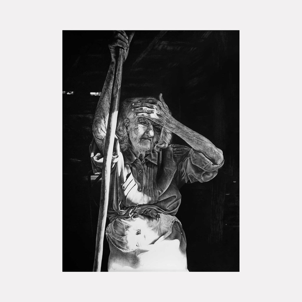 The artwork "BRUTAL LIGHT II" by Lisyanet Rodriguez features a highly detailed black and white drawing of an elderly figure holding a long staff, with one hand shading their face from a harsh, dramatic light. The textured rendering and stark contrasts evoke the intense realism and chiaroscuro reminiscent of Caravaggio and the emotional depth found in KÃ¤the Kollwitzâ€™s portraits.