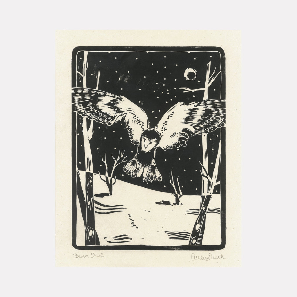 The artwork "Barn Owl" by Ashley Ranae Quick features a detailed black and white illustration of a barn owl with outstretched wings flying over a snowy landscape at night. The scene includes leafless trees, a starry sky, and a crescent moon, rendered in a bold, graphic style with strong contrasts and textured lines.