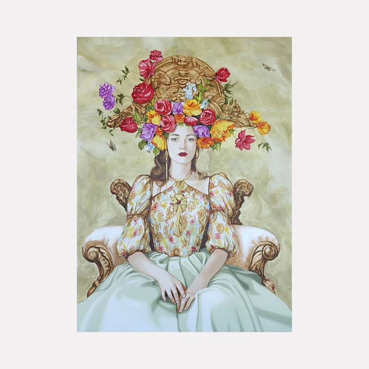 The artwork "Bloom of Thoughts" depicts a serene woman seated on an ornate vintage chair, wearing a floral-patterned blouse and a pale green skirt. A large, elaborate floral arrangement with red, purple, yellow, and pink flowers crowns her head, mixing natural textures with a soft, muted background. By Carlos Gamez de Francisco.