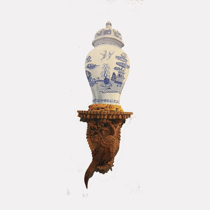 The artwork "Blue Willow" by Carl Chaiet, gallery position 1, features a classic porcelain vase adorned with intricate blue chinoiserie motifs depicting birds, pagodas, and willow trees. The vase rests on an ornately carved wooden bracket with detailed textures, reminiscent of the refined elegance and craftsmanship found in the works of Joseph Paxton and William Morris.