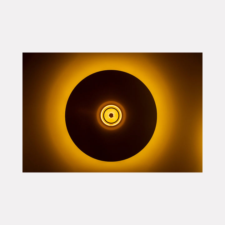 Circles and Light by Steve Edson presents a minimalist, radiant design featuring concentric circular forms with a warm, glowing amber light that softly diffuses around the central shapes, evoking a sense of calm illumination and harmonious balance within a modern, abstract composition.