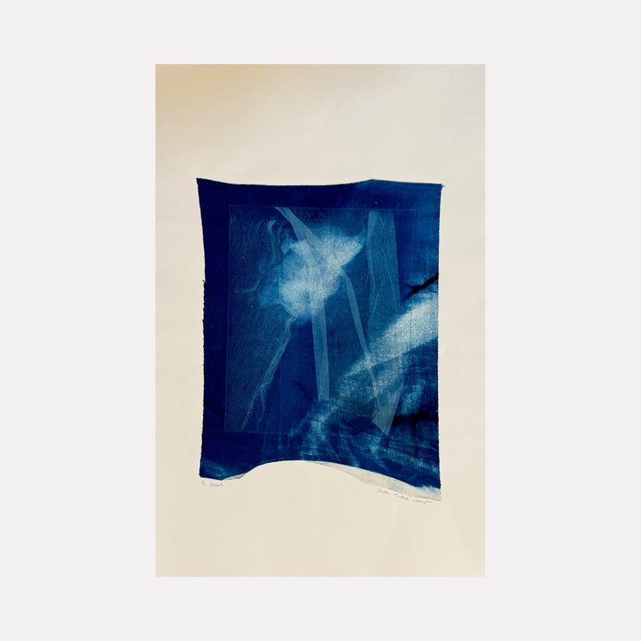 The artwork "Cyanotype Veil 1" features deep indigo and cyan hues with layered, translucent veil-like shapes creating a soft, ethereal texture. The composition blends abstract forms and subtle gradients reminiscent of traditional cyanotype prints on light beige paper. By Starr Tucker-Ortega.