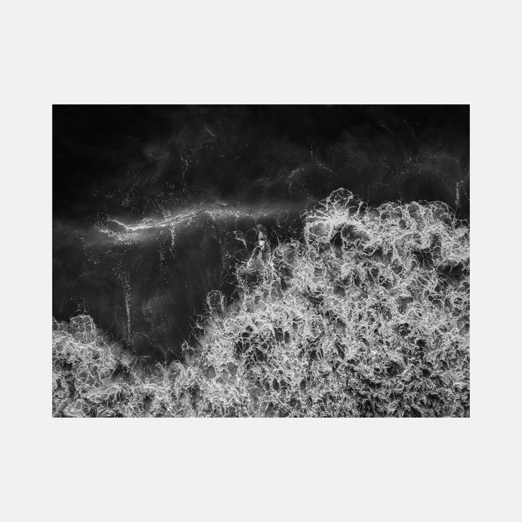 The artwork "Back Out" by Dennis Maida features an abstract black and white composition resembling turbulent ocean waves with intricate, lace-like textures and dynamic swirling patterns. The style evokes the stark contrasts and fluid forms similar to the works of Ansel Adams and Hiroshi Sugimoto. Dennis Maida.