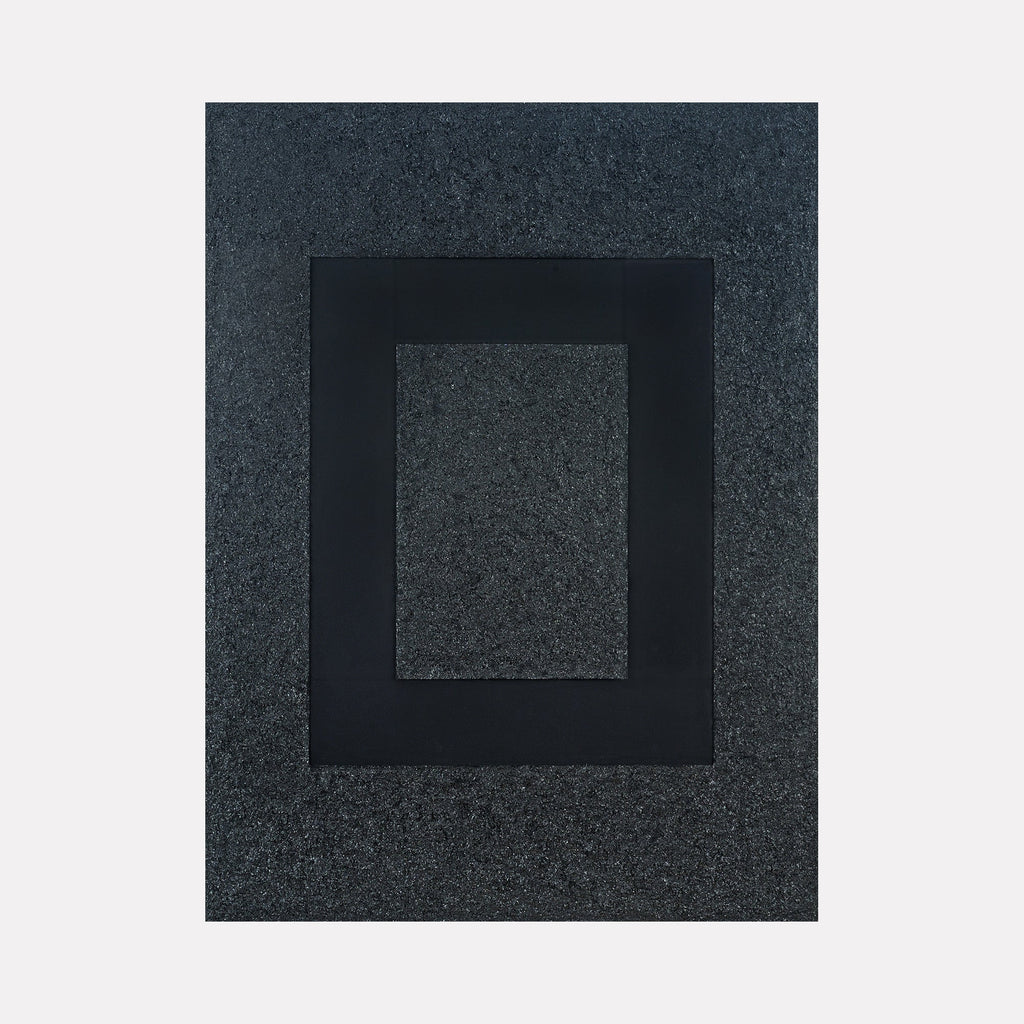 The artwork "Tough as Diamonds" by Dina AZ Salem features a minimalist composition with a textured, granular background in deep charcoal gray, layered with a bold, smooth black rectangular frame at the center. The contrast of rough and sleek surfaces evokes the abstract geometric style of Josef Albers and the material focus seen in Anish Kapoor’s monochromatic sculptures.