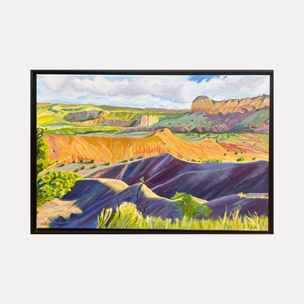 The artwork "Dreamland" by Connie Falk features a vibrant landscape with rolling hills and mesas in rich hues of orange, purple, and green, reminiscent of the bold color palettes and fluid forms found in the works of Georgia O'Keeffe. The textured brushstrokes and dynamic composition evoke a serene yet dramatic natural scene bathed in sunlight under a partly cloudy sky.