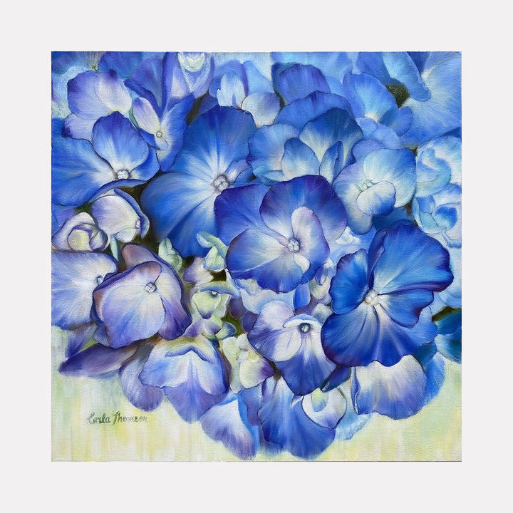 The artwork "Echoes of Blue" by Carla Thomson features a close-up composition of blue hydrangea flowers rendered with soft, smooth brushstrokes and delicate gradients. The petals showcase varying shades of blue and violet with hints of white and green, evoking a serene and calming atmosphere reminiscent of Georgia O’Keeffe’s floral paintings and the luminous textures of Impressionist art.