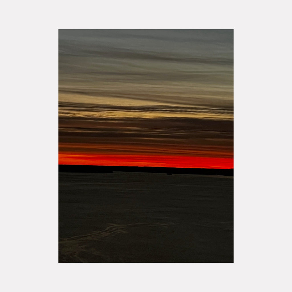 The artwork "Fire & Ice 1" by Starr Tucker-Ortega features a dramatic horizon with a stark contrast between deep fiery red and muted icy gray tones. The sky displays layered wispy clouds transitioning from warm orange and red near the horizon to cooler grays and blues above, evoking a serene yet intense natural landscape. Starr Tucker-Ortega