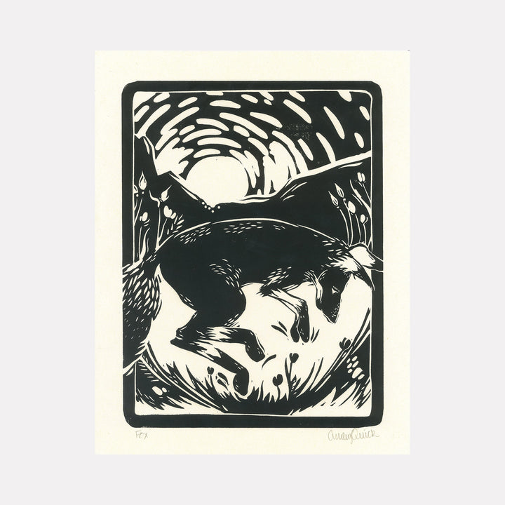 The artwork "Fox" by Ashley Ranae Quick depicts a stylized black and white fox leaping energetically in a natural landscape with rolling hills and a radiant sun or moon in the background. The woodcut-style print uses bold contrast and dynamic lines to create texture and movement, emphasizing the fox's graceful form. Ashley Ranae Quick