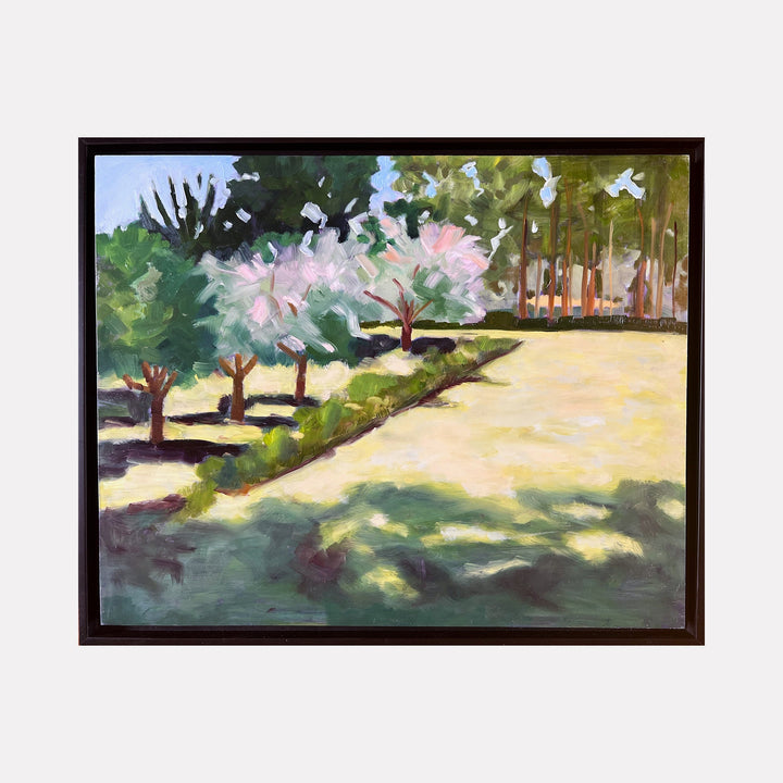 The artwork "Gutierrz-Hubbell House Orchard" by Connie Falk features a serene orchard scene with soft, impressionistic brushstrokes reminiscent of Claude Monet’s style. The painting uses a gentle palette of greens, light pinks, and earthy tones to depict blossoming trees, dappled sunlight, and shadowy ground textures, evoking a peaceful natural landscape.