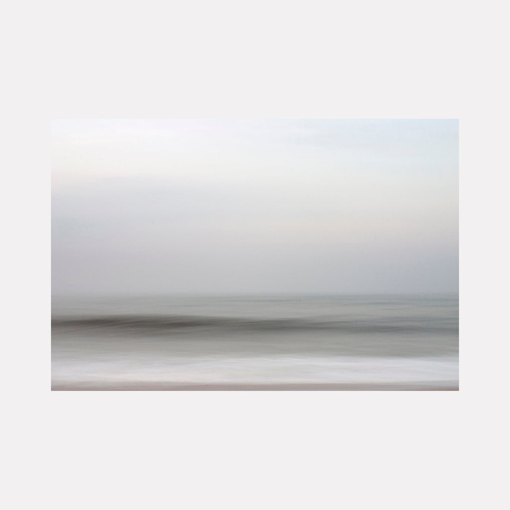 The artwork "Harmony" by Sandi Daniel features a tranquil abstract seascape with soft, blurred horizontal layers in muted grays, whites, and pale blues. The gentle gradations and smooth textures evoke a serene atmosphere reminiscent of the minimalist landscapes by Hiroshi Sugimoto and the ethereal quality of Mark Rothko’s color fields.