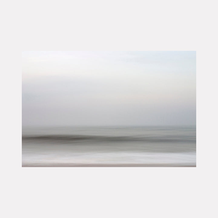The artwork "Harmony" by Sandi Daniel features a tranquil abstract seascape with soft, blurred horizontal layers in muted grays, whites, and pale blues. The gentle gradations and smooth textures evoke a serene atmosphere reminiscent of the minimalist landscapes by Hiroshi Sugimoto and the ethereal quality of Mark Rothko’s color fields.