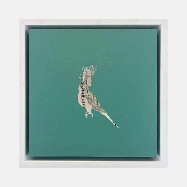 The artwork "Profit Margins, Cockatoo" by Jacki Davis features a silhouette of a cockatoo crafted from US currency embedded on a teal acrylic background on a wood panel, measuring 8 by 8 inches, showcasing textured layers and minimalist composition.