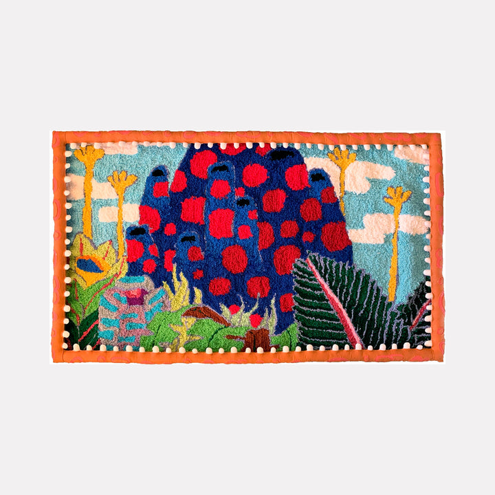 The artwork "Harvest" by James Hsieh features a vibrant textile composition with bold, organic shapes in deep blues and reds, punctuated by bright orange and lush green foliage against a light blue sky with stylized clouds. The rich textures and playful patterning evoke the dynamic, nature-inspired abstraction reminiscent of Henri Matisse’s cut-outs and Yayoi Kusama’s polka dots.