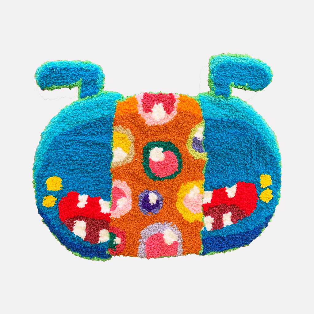 The artwork "What Is Essential Is Invisible To The Eye" by James Hsieh features a vibrant, textured abstract creature with bold patches of turquoise, orange, red, and yellow. Its playful, tufted loops and circular motifs recall the whimsical surrealism and bright color palettes of artists like Takashi Murakami and Yayoi Kusama.
