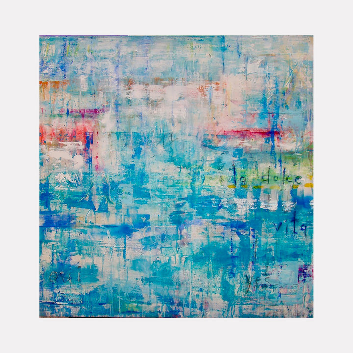 The artwork "LA DOLCE VITA" features a layered abstract composition with dominant shades of blue, turquoise, and hints of pink, orange, and white. The textured brushstrokes create a sense of depth and movement, with subtle text elements faintly visible in the background. This vibrant, modern piece expresses a dreamy, fluid aesthetic by Amadea Bailey.
