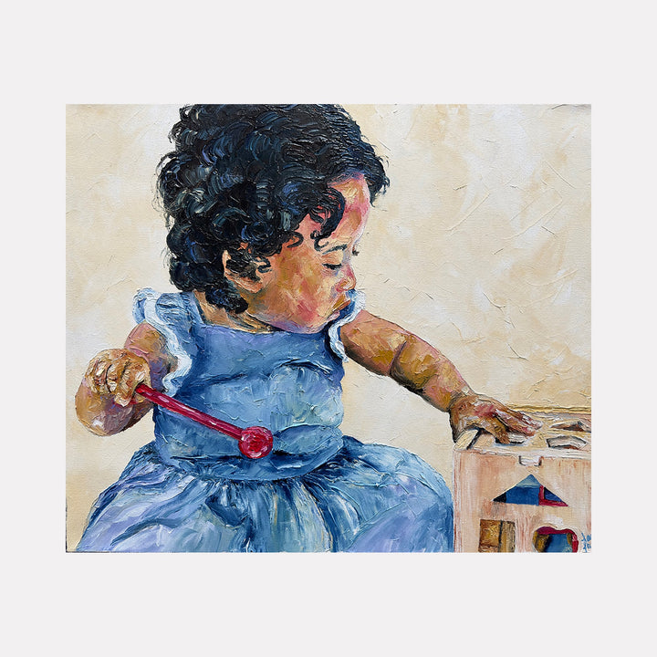 The artwork "Lily's Playtime" depicts a young child with curly dark hair wearing a textured blue dress, engaged in play with a wooden toy featuring colorful geometric shapes, painted in detailed oil strokes capturing soft skin tones and delicate light on a neutral background. Painted by Lauren Luna.