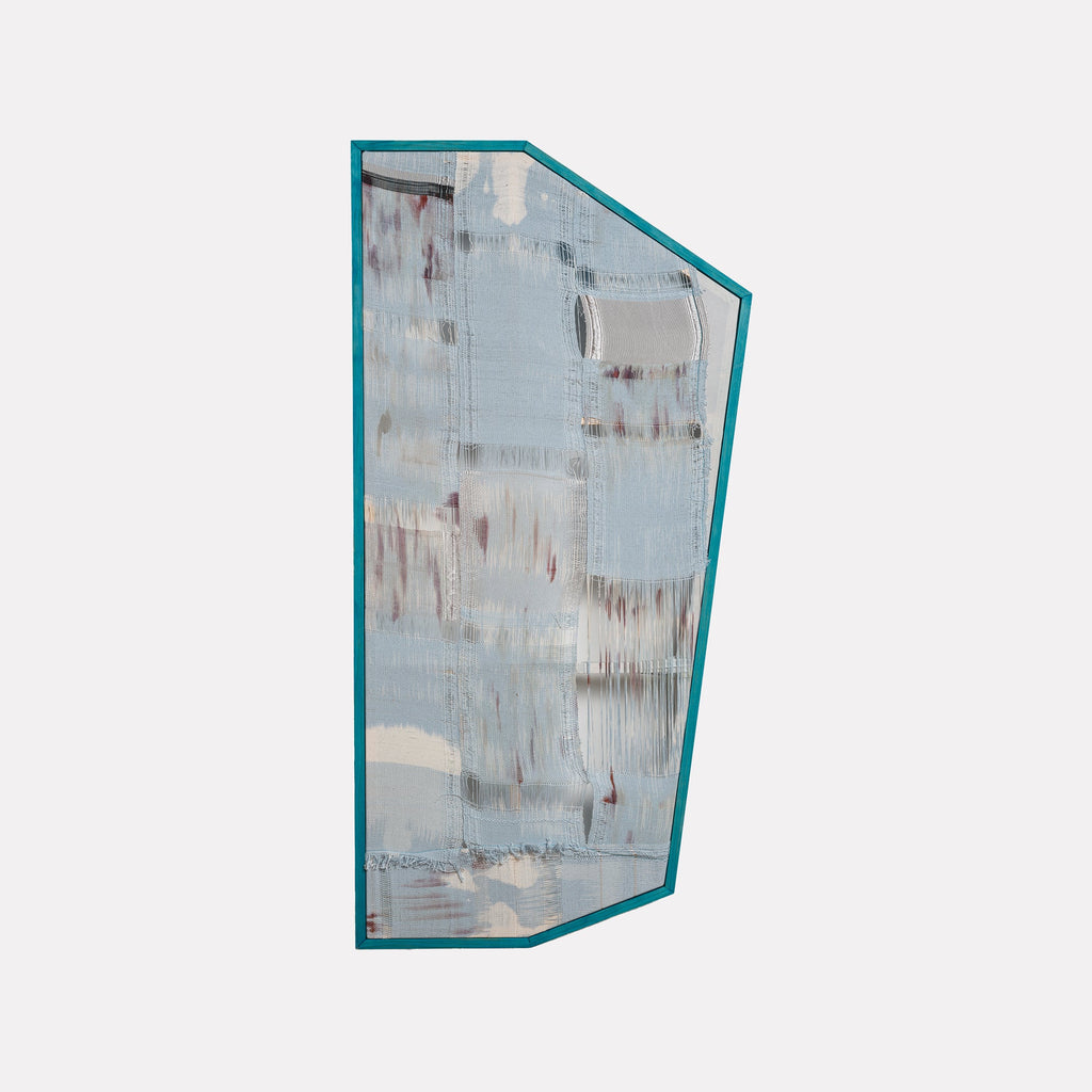 The artwork "Untitled #17" by Victoria Manganiello features an abstract composition with a textured surface dominated by muted blue and gray tones, accented with subtle hints of rust and white. The irregular shape is outlined with a teal border, enhancing its modern and minimalist aesthetic. Victoria Manganiello.