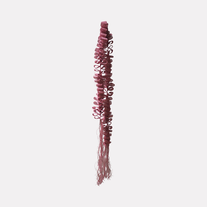 The artwork "Desire Paths" by Morgan Hale features a vertical, textured sculpture composed of intricate, looped pink fibers that cascade down into delicate fringe. Its organic form and playful structure echo the tactile qualities of Louise Bourgeois’s soft sculptures and the minimal, repetitive patterns reminiscent of Eva Hesse’s fiber works.