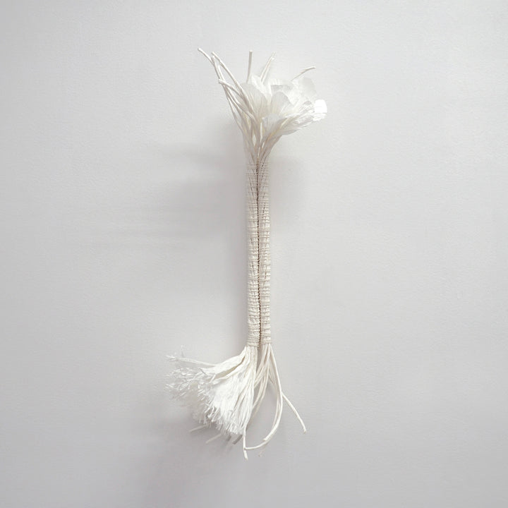 The artwork "Two For You" by Morgan Hale features a minimalist sculptural form composed of delicate, intertwined white fibers arranged vertically against a neutral background. The piece evokes the organic textures and refined simplicity reminiscent of Agnes Martin’s subtle abstract works and Eva Hesse’s tactile sculptures, highlighting natural elegance and subtle complexity.
