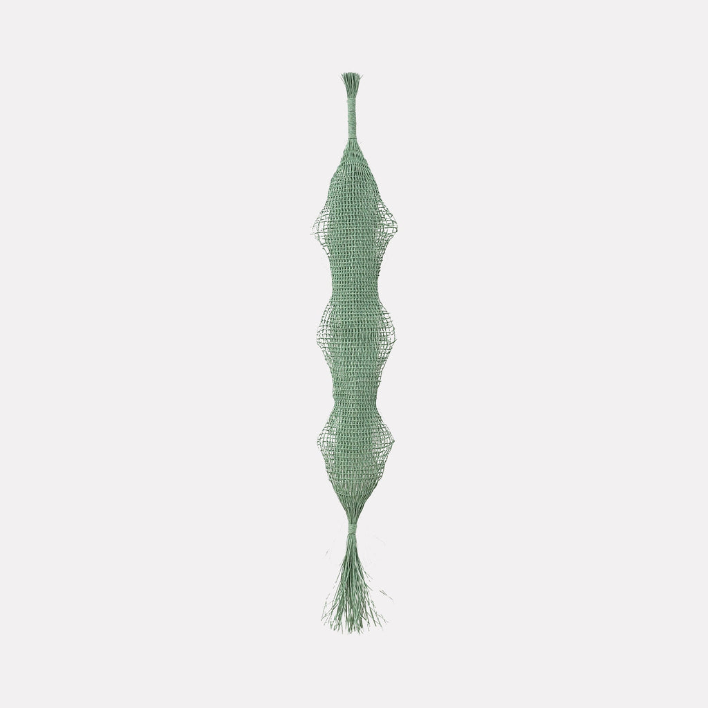 The artwork Verdant Pendant by Morgan Hale features an elongated, symmetrical green textile sculpture with a textured, woven mesh surface. Its organic, undulating form evokes the tactile abstraction found in Eva Hesse's sculptures, blending delicate fiber art with minimalistic, modernist aesthetics reminiscent of Brancusi's refined simplicity.