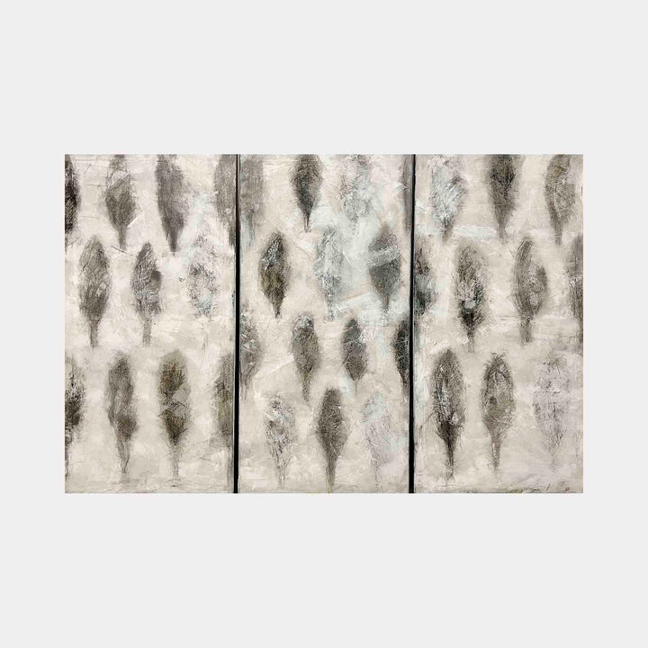 The artwork "Orchard" by Shira Toren features a triptych abstract landscape with textured vertical forms resembling silhouetted trees in muted grays and neutral tones. The layered brushstrokes and subtle tonal shifts create a serene, atmospheric effect reminiscent of the minimalist textures in Mark Rothko’s color fields and the natural motifs found in Agnes Martin’s work.