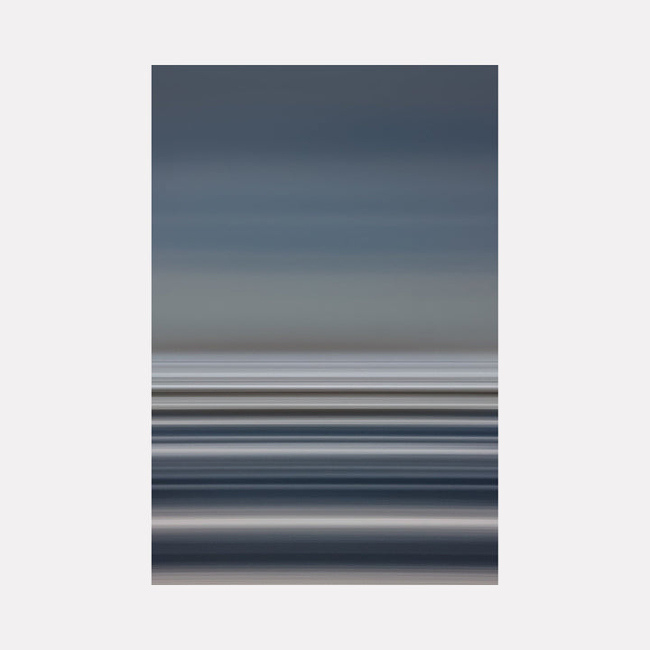 The artwork Pacific Sun Belts by Neil Shapiro features horizontal bands of muted blues, grays, and soft whites, creating a serene and minimalistic abstract landscape. The smooth gradients and layered textures evoke the calming atmosphere of dusk or dawn, reminiscent of Mark Rothko’s color field paintings and Agnes Martin’s subtle linear abstractions.