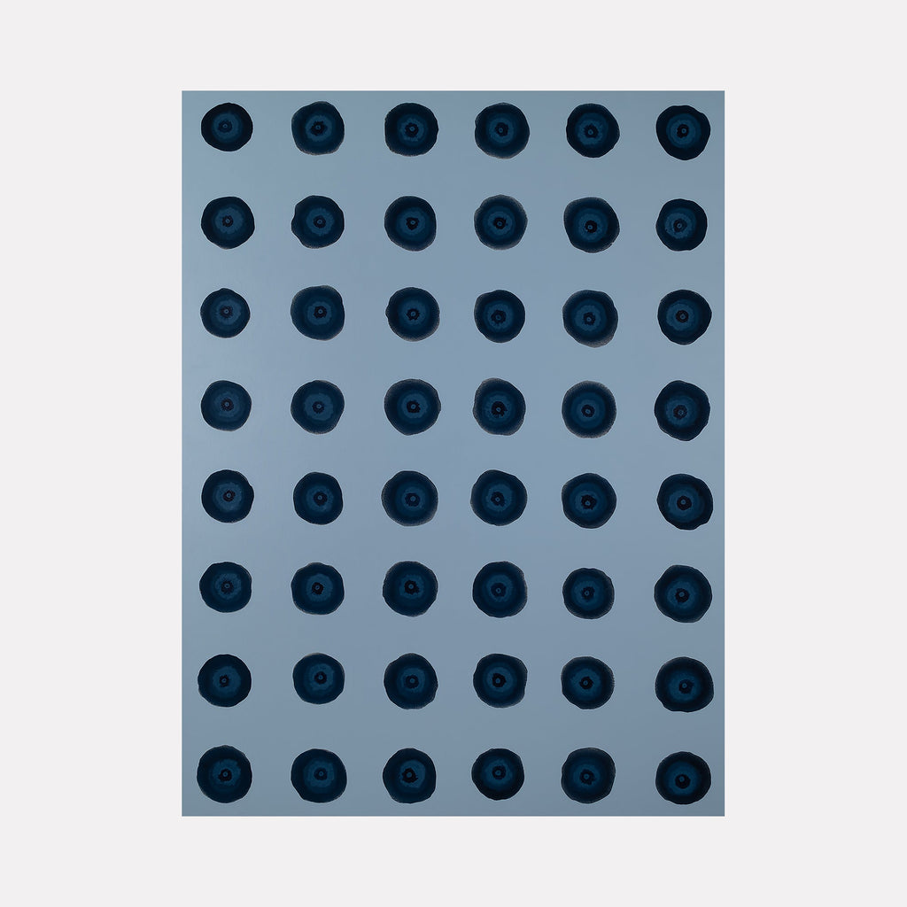 The artwork "#1 (Prussian Blue)" by Patrick Walsh in gallery position 1 presents a grid of deep blue circular forms against a muted slate background. Each shape features textured layers and organic imperfections, evoking the meditative repetition found in Agnes Martin’s work and the moody abstraction reminiscent of Yves Klein’s monochromes.
